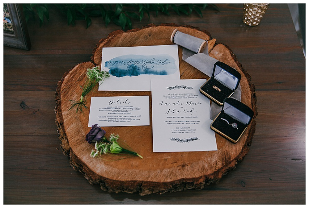 First Wedding at The Farmhouse wedding rings with invitation on wood block